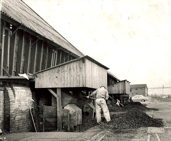 6. Shovelling the coal into the fires that supplied heat through the flues under the Pan. Murgatroyd's.jpg